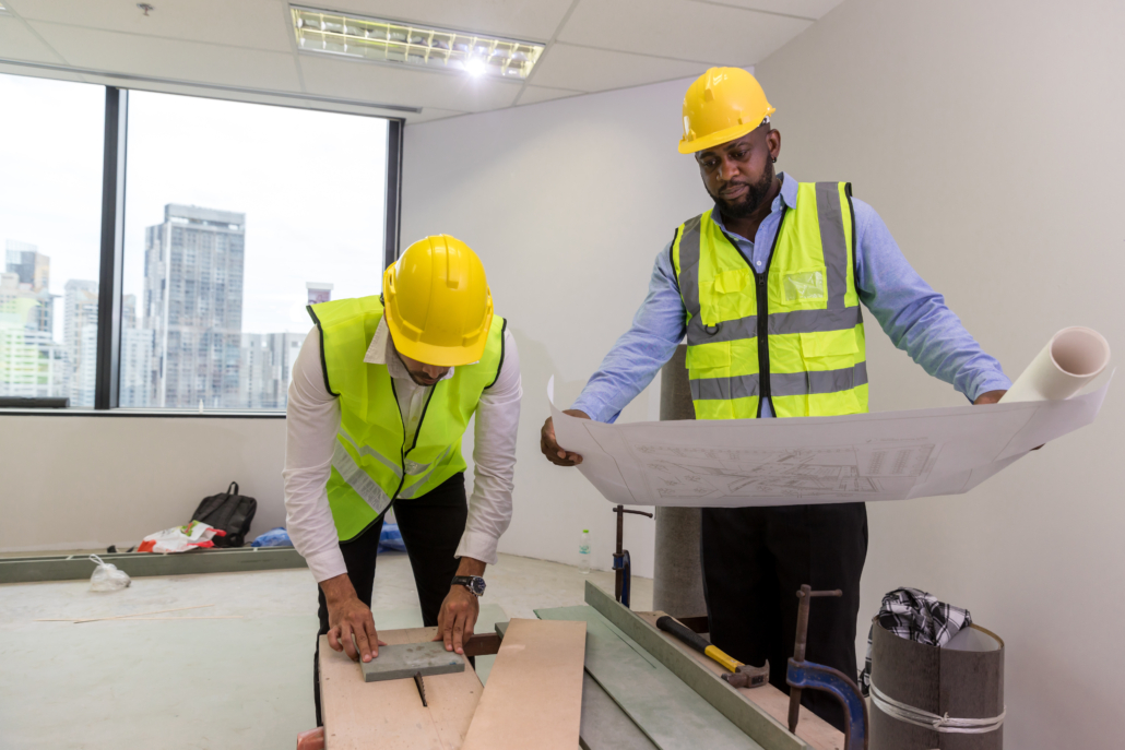 Team Engineers with draft plan of building on constructing site. office construction